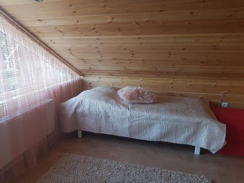 a bed in a room with a wooden ceiling at Advance in Narva-Jõesuu