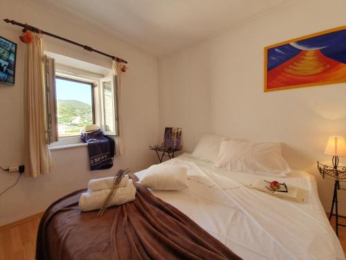 Un dormitorio con una gran cama blanca con ventana. en Central Gem - ZF Hvar House, en Hvar