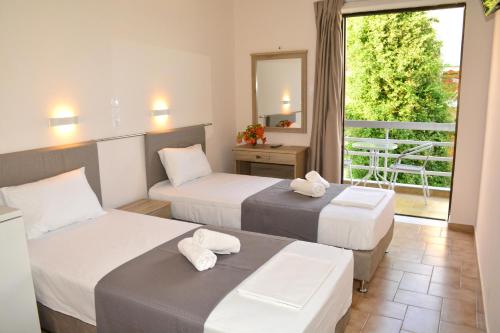 a hotel room with two beds and a balcony at GOLDEN STAR in Agia Marina Aegina