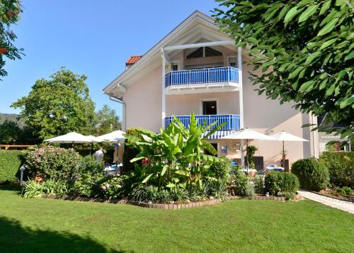 a house with a garden and umbrellas at Happy Lake by Thomas Strugger in Krumpendorf am Wörthersee