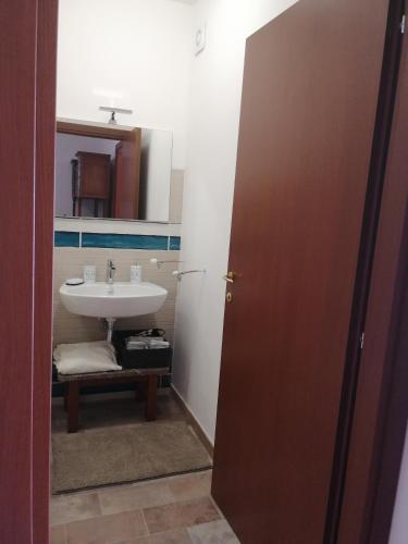 a bathroom with a sink and a mirror and a door at Casa Romeo in Taormina