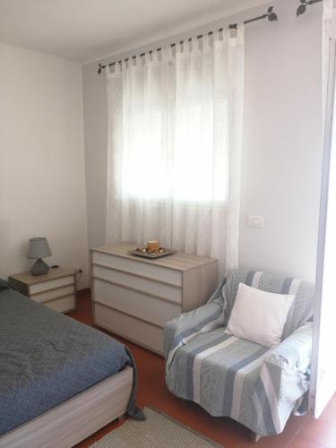 a bedroom with a bed and a chair and a window at Casa Romeo in Taormina