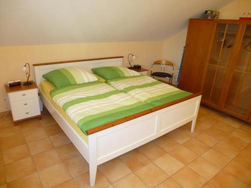 a bedroom with a bed with a green and white comforter at TOP Ferienwohnung Limburg "Am Bildstock" in Limburg an der Lahn
