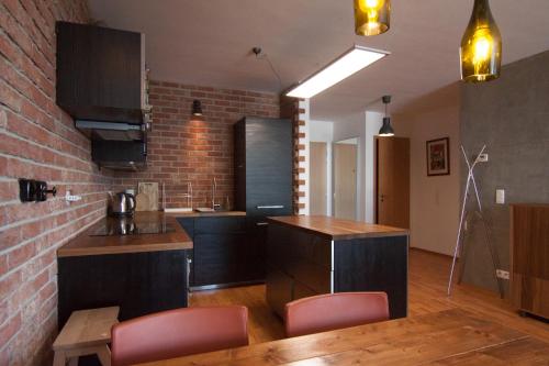 a kitchen with brown cabinets and a brick wall at Bajka 09 -Self Check - Free parking in Bratislava