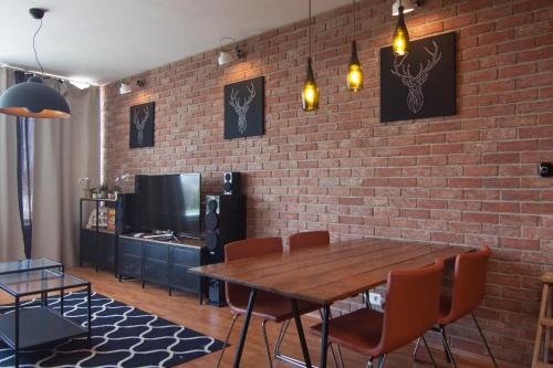 a dining room with a brick wall and a table and chairs at Bajka 09 -Self Check - Free parking in Bratislava