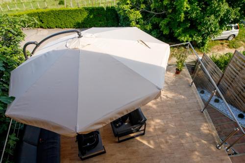 a white umbrella is sitting on a patio at Panoráma Csopak in Csopak
