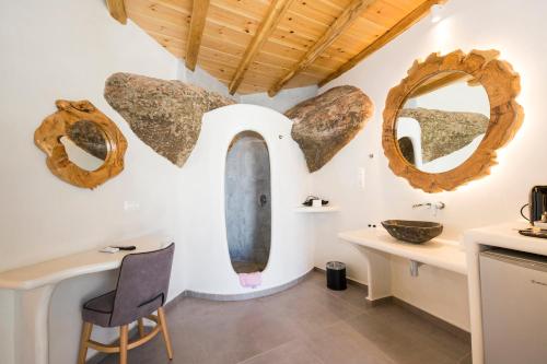 a room with a sink and mirrors on the wall at Sahas Suites in Mikonos
