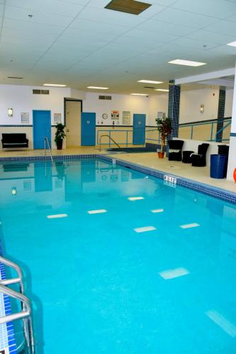 a large swimming pool with blue water at Coast Lethbridge Hotel & Conference Centre in Lethbridge