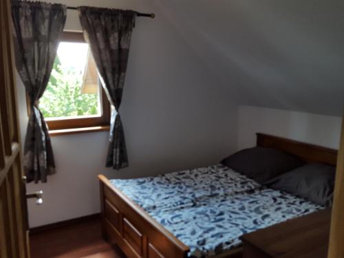 een slaapkamer met een bed en een raam bij Domek Saracena in Stegna