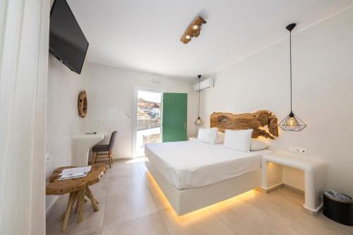 een slaapkamer met een bed, een bureau en een televisie bij Sahas Suites in Mykonos-stad
