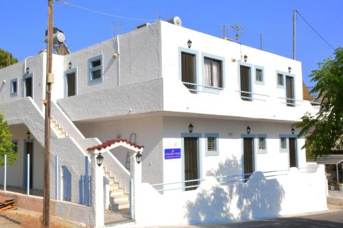 a white house with a staircase in front of it at Golden Star Praxitelous in Agia Marina Aegina