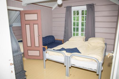 a small bedroom with a bed and a window at lunde slusevaktarbolig in Lunde