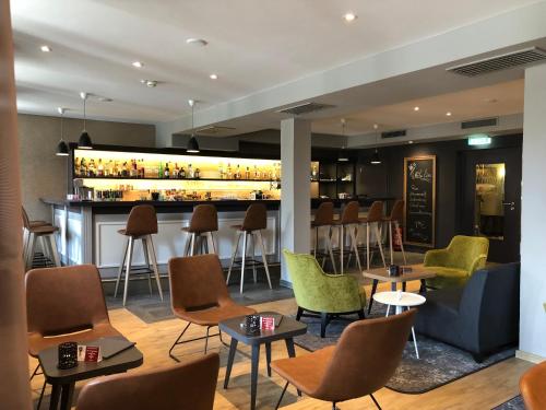 a bar in a restaurant with chairs and tables at Best Western Plus Parkhotel Maximilian Ottobeuren in Ottobeuren