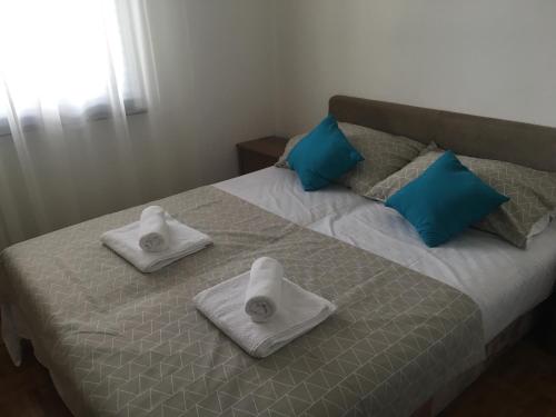 łóżko z ręcznikami i poduszkami na górze w obiekcie Apartment Sandrina w Novalji