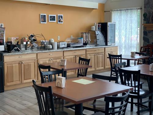 a restaurant with tables and chairs and a kitchen at The Lodge at Jackson Village in Jackson