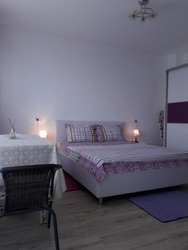 ママイアにあるStudio Sunset Violetのベッドルーム1室(ベッド2台、テーブル、ランプ2つ付)