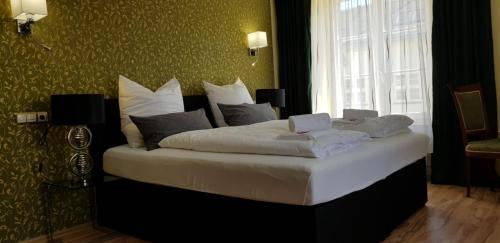 1 dormitorio con 1 cama con sábanas blancas y ventana en Hotel-Villa Lalee, en Dresden