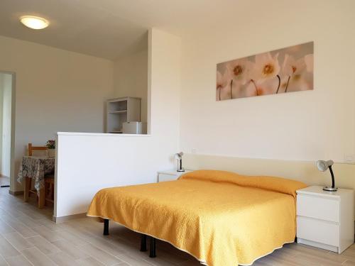 Mini Appartamenti Elba في لاكونا: غرفة نوم بسرير ودهان على الحائط