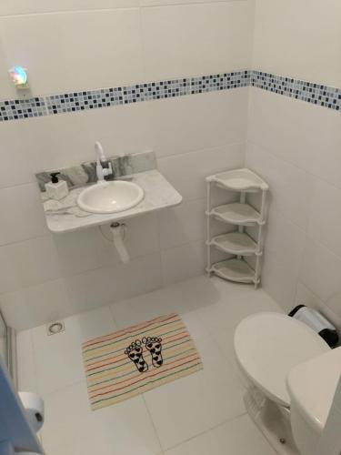 a white bathroom with a sink and a toilet at Casa de Mainha Friendly Hostel in Salvador