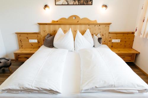 1 Schlafzimmer mit 2 Betten und weißen Kissen in der Unterkunft Ferienwohnung Bognerhof in Sankt Veit im Pongau