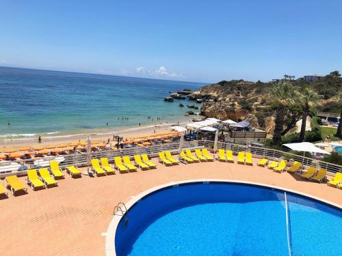 a swimming pool with chairs and a beach at Borda d`Água, Praia da Oura in Albufeira