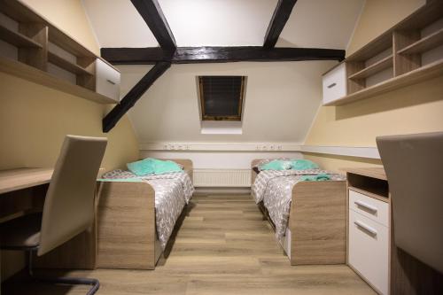 two twin beds in a room with a desk at MINIDORM ROOMS IN HEART OF CITY CENTER in Maribor