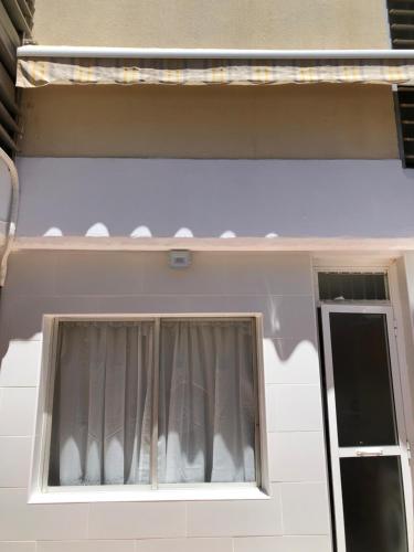 a building with a window with a curtain at Calle de Frederica Montseny 'Política' Casa o chalet in Valencia