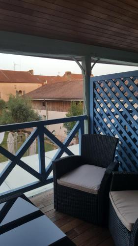 a chair on a porch with a blue fence at HOTEL DE FRANCE in Maubourguet