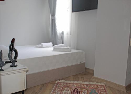 um quarto branco com uma cama e uma janela em Good Night Hotel Istanbul em Istambul