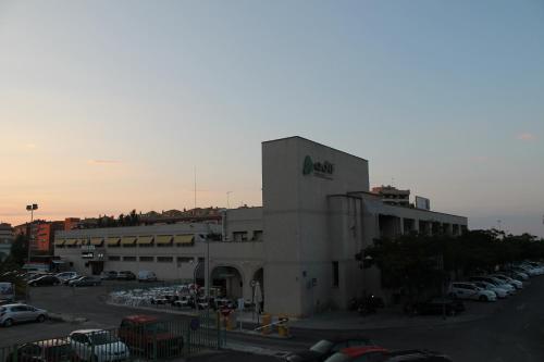 a large building with cars parked in a parking lot at Hostal Restaurante EstaciÓN in Jaén