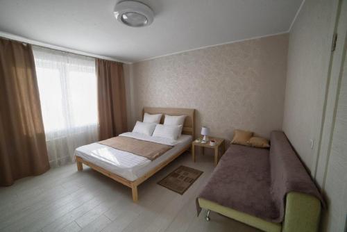 1 dormitorio con 2 camas y ventana en PaulMarie Apartments on Kozlova, en Soligorsk