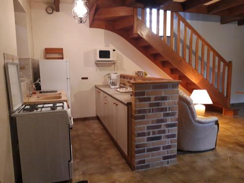 une cuisine avec cuisinière et un escalier dans l'établissement Les Roses Trémières, à Trans