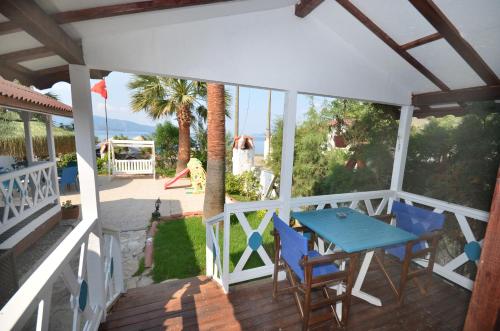 un patio con mesa y sillas en una terraza en Blu Brezza Marine Hotel, en Hisarönü