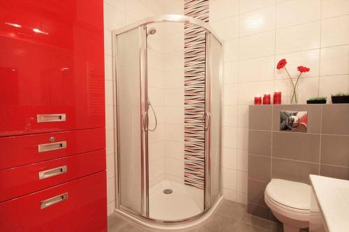 ein rotes Badezimmer mit einer Dusche und einem WC in der Unterkunft KONWALIA in Zakopane