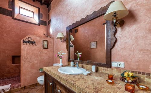a bathroom with a sink and a large mirror at Casa Gaida in Tías