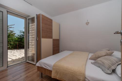 a bedroom with a bed and a sliding glass door at Apartment Nives in Trogir