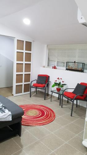 a living room with two chairs and a red rug at Amazing in Haifa