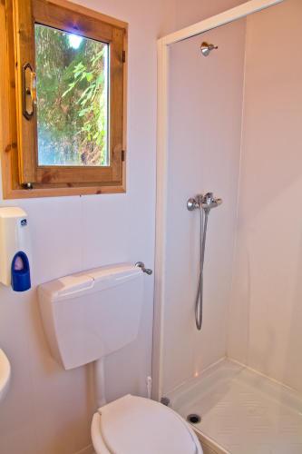 a bathroom with a toilet and a window at Anthares World Resort in Candia Canavese