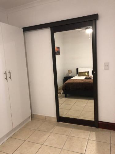 una camera con un letto e un grande specchio di Sweet Home Alibama a Nelspruit