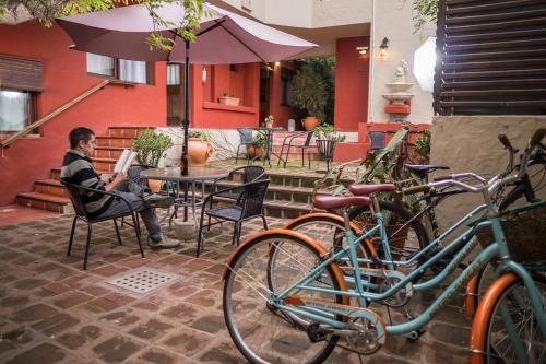コロニア・デル・サクラメントにあるViajero Posada B&Bの自転車の横のテーブルに座っている男