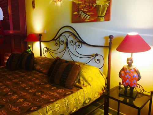 a bedroom with a bed with a lamp and a statue at Maison Couleur Passion in Nianing