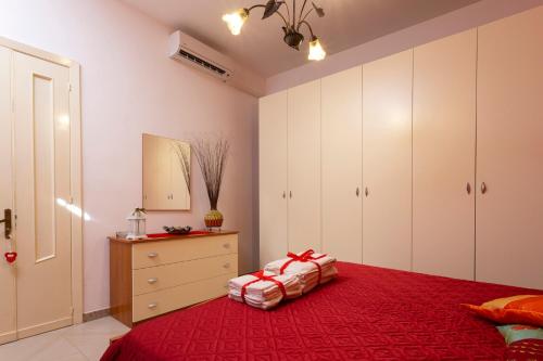 - une chambre avec un lit rouge et une commode dans l'établissement Rifugio Delle Nereidi, à Marina di Mancaversa