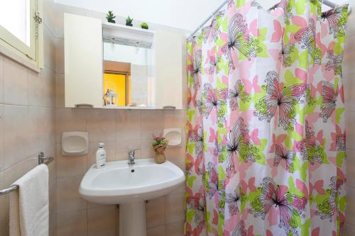 La salle de bains est pourvue d'un lavabo et d'un rideau de douche. dans l'établissement Rifugio Delle Nereidi, à Marina di Mancaversa