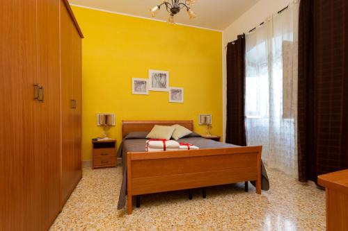 a bedroom with a bed and a yellow wall at Il rifugio dei Narratori in Marina di Mancaversa