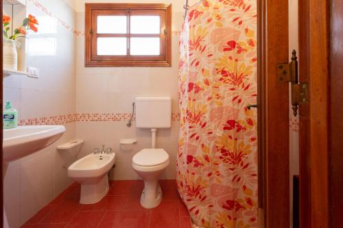 ein Bad mit einem WC, einem Waschbecken und einem Fenster in der Unterkunft Il rifugio dei Narratori in Marina di Mancaversa