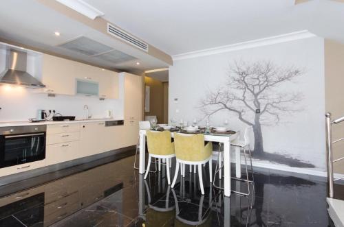 a kitchen with a table with yellow chairs at CTS Elysium Residence Taksim in Istanbul
