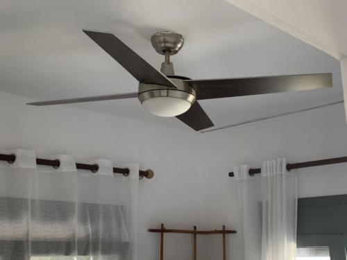 a ceiling fan in a room with a window at Villa Rena In Front of the Sea in Arkoudi