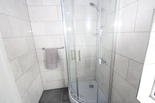 a bathroom with a glass shower with a toilet at Windsor House in Slough