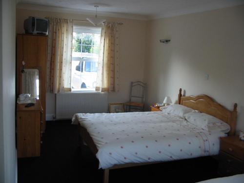 1 dormitorio con cama y ventana en Home farm cottage Guest House en Norwich