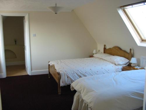 um quarto com 2 camas e uma janela em Home farm cottage Guest House em Norwich
